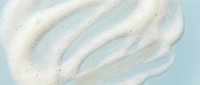 White cream swirl with sparkles on light blue background. Cosmetic texture for skincare and beauty product design applications.