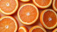 Fresh orange slices arranged in rows showing juicy pulp and vibrant texture on coral background, top view composition for healthy eating and vitamin C concept.