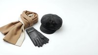 Stylish winter accessories set with wool scarf, leather gloves and newsboy cap arranged on white background for fashion and seasonal wear concepts.