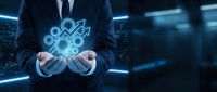 Businessman in dark suit holding glowing digital gears and cogs hologram, representing technology, innovation, and industrial automation solutions.