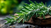 Fresh rosemary sprigs on rustic wooden cutting board with natural green bokeh background for culinary cooking and herb garden concepts.