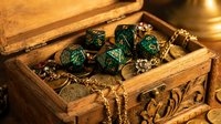 Ornate wooden treasure chest filled with emerald green polyhedral dice, gold chains, and metallic gaming accessories for tabletop role-playing games and fantasy adventures.