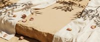 Handmade natural soap bar with nuts on linen fabric with botanical shadows, organic skincare and spa concept for wellness and beauty routines.