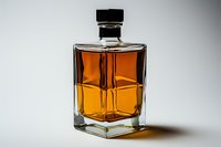 Square glass bottle with amber liquid casting dramatic shadows on light background, elegant minimalist composition highlighting luxury spirits and beverage packaging.