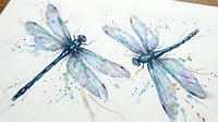 Watercolor dragonflies with translucent wings in blue and purple hues on white paper. Artistic nature illustration with paint splatters for home decor.