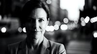 Professional businesswoman portrait in black and white with city lights bokeh background for corporate marketing and executive headshot concepts.