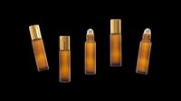 Amber glass roller bottles with gold caps, isolated on transparent background. Ready for stickers, print on demand, T-shirt design, sublimation, and clipart use.