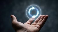 Businessman hand holding glowing refresh icon symbol for system update, restart, reload, and renewal concept for technology and digital transformation.