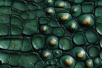 Emerald green crocodile leather texture with metallic gold accents showing detailed scales, bumps and natural pattern. Luxury fashion background macro photography.