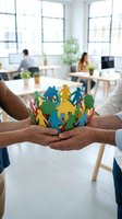 Diverse team of colleagues holding colorful paper cutout figures in circle formation, symbolizing unity, teamwork and community support in modern office environment with natural light.
