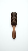 Wooden paddle brush with natural boar bristles and elongated oval head on white background for hair care and grooming product photography.