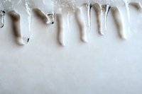 Dripping white paint or glue creating abstract pattern on light background. Artistic fluid texture with natural shadows and flowing elements for creative design projects.