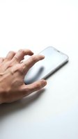 Male hand with light skin tone using wireless mouse on white smartphone for work, business, or digital technology concepts.