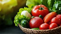 Fresh organic vegetables in wicker basket with ripe tomatoes, carrots, lettuce and greens for healthy cooking and nutrition.