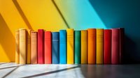 Row of colorful hardcover books standing on gray surface against yellow and turquoise wall with dramatic diagonal shadow, education and literature concept.