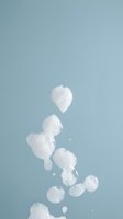 Floating white jellyfish with translucent bells and trailing tentacles against serene blue ocean water background, suitable for marine life and underwater themed designs.