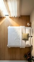 Cozy attic bedroom with white bedding and natural light streaming through skylight window creating warm atmosphere for relaxation and rest.