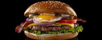 Juicy beef burger with fried egg, crispy bacon, fresh vegetables, and melted cheese on sesame seed bun against dark background, panoramic shot for menu or advertising.