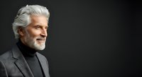 Mature man with white hair and beard, wearing dark blazer and turtleneck, isolated against black background for corporate and professional design use.