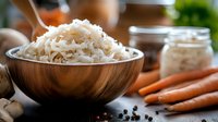 Fresh fermented sauerkraut in wooden bowl with raw carrots and peppercorns on rustic wooden table, traditional probiotics for gut health and immunity.