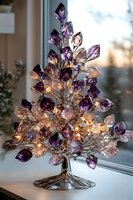 Decorative crystal tree with purple and clear gemstones illuminated by warm LED lights, creating magical glow against window. Elegant holiday home decor piece.