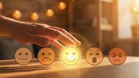 Wooden emoji faces arranged in a row with hand selecting the glowing happy face, representing customer satisfaction, feedback rating, and service quality evaluation.