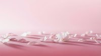 Clear water droplets and splashes on soft pink gradient background creating fresh clean liquid motion for cosmetic and skincare product advertising.