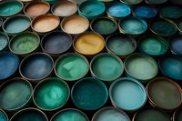 Paint cans filled with various shades of blue, green, and brown creating an artistic pattern of circles, suitable for interior design and renovation concepts.