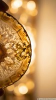 Golden whiskey glass with ice cubes and warm bokeh lights creating luxurious ambiance for celebration and premium spirits advertising.