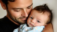 Tender moment between father and baby in soft natural light. Close up portrait showing emotional connection and gentle parental care. Peaceful family bonding scene.
