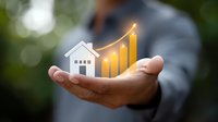 Businessman holding glowing house icon with rising graph chart, representing real estate market growth and property investment success in finance sector.