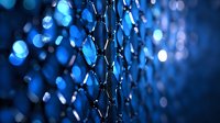 Chain link fence with water droplets creating bokeh lights in blue twilight atmosphere for security and protection concepts.