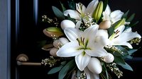 White oriental lilies and delicate baby's breath create elegant floral arrangement against dark background, perfect for wedding, sympathy or special occasion designs.