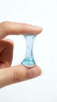 Close-up of hand holding stretchy blue gel or slime between fingers, demonstrating elasticity and viscosity for skincare, cosmetics, or product testing applications.