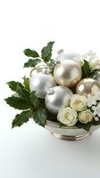 Elegant silver and gold Christmas ornaments arranged with white roses and holly leaves in decorative bowl on white background for holiday decor.