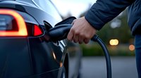 Man charging electric vehicle at station with glowing cable connection and modern car design for sustainable transportation and eco-friendly mobility solutions.