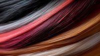 Smooth flowing strands of hair in multiple colors including black, red, copper and silver create dynamic waves and curves against dark background.