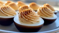 Chocolate mousse cups topped with caramel swirl frosting and cinnamon dust, elegant dessert presentation for bakery, confectionery, and fine dining culinary use.