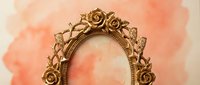 Ornate golden vintage mirror frame with roses and decorative elements against soft coral watercolor background for romantic interior design projects.