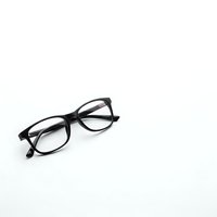 Black frame eyeglasses isolated on white background for optical shop advertising and vision care marketing materials.