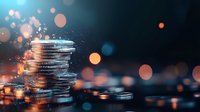 Stacked silver coins with glowing bokeh lights and sparkles on dark blue background, financial concept for wealth, savings and investment success.