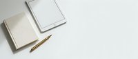Minimalist workspace with blank notebooks, wooden pencil and tablet on clean white surface for creative projects and planning.