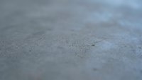 Macro close-up of concrete surface texture with fine dust particles and subtle shadows, suitable for backgrounds, construction materials, industrial design, and architectural projects.