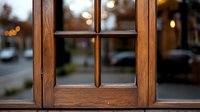 Wooden window frame detail with blurred bokeh city lights background, view from inside. Natural oak wood texture with traditional divided glass panes.