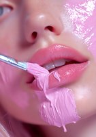 Close-up of pink glossy lips with makeup brush applying creamy pink lipstick, artistic beauty shot with soft focus and dreamy pink tones for cosmetic advertising.
