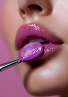 Close-up of glossy purple lipstick application on plump lips against pink background, showing professional makeup artistry technique and cosmetic product texture.