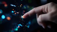 Finger touching glowing particles with magical light effect against dark background, creating ethereal atmosphere with blue and orange bokeh lights.