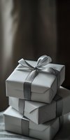 Elegant white gift boxes stacked with silver ribbon bows on neutral background, creating sophisticated minimalist composition for special occasions and celebrations.