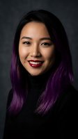 Young Asian woman with purple hair highlights smiling confidently in professional portrait against dark background for business and lifestyle content.