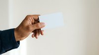 Hand holding blank white card isolated on light background, ready for custom text or branding design for business, marketing, or promotional use.